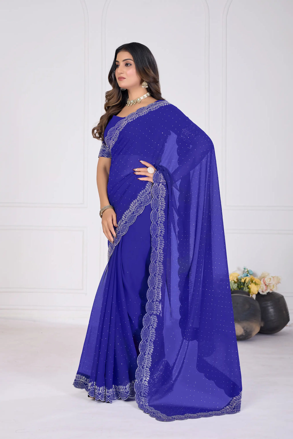 Woman wearing a blue saree with silver border on a white background