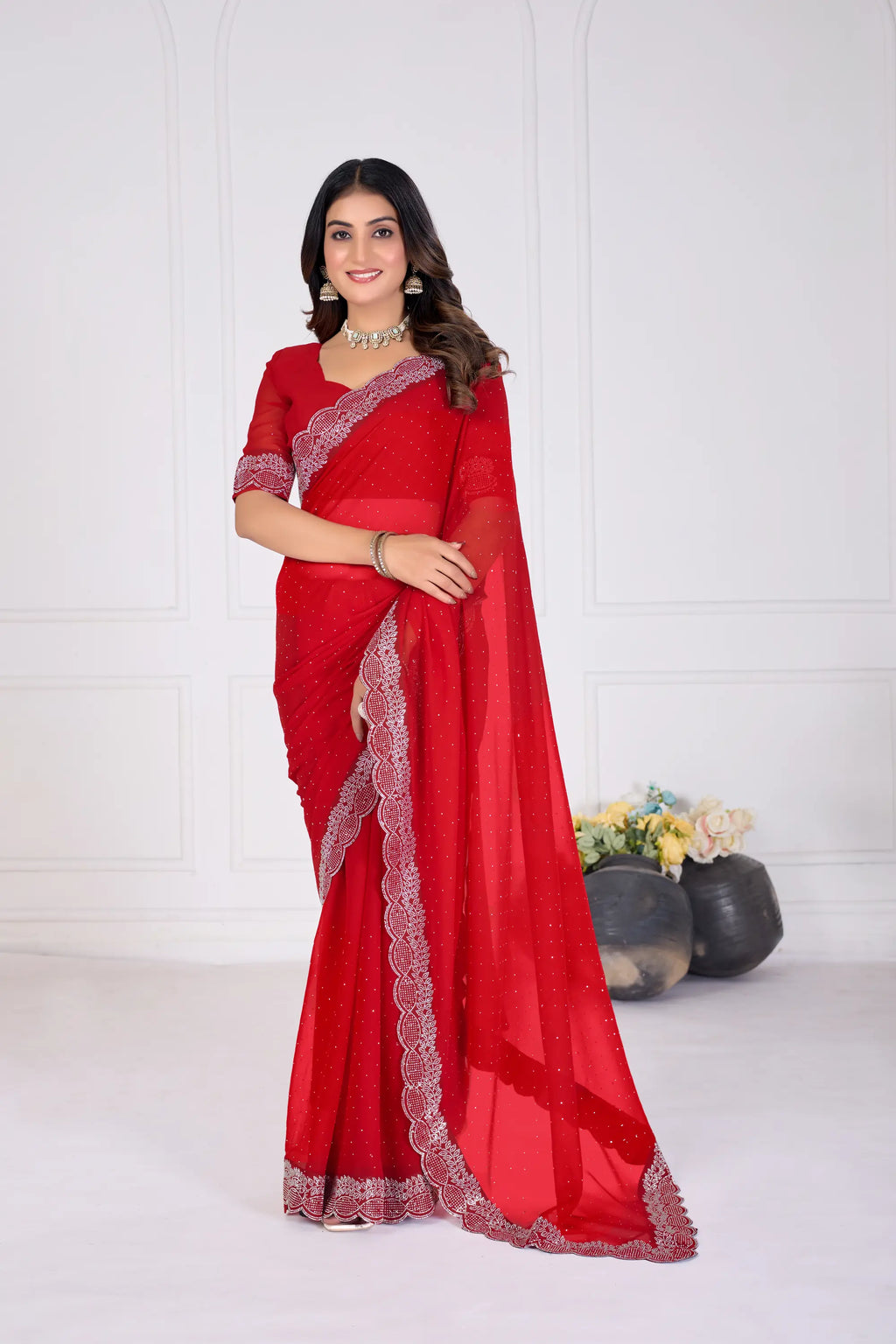 Woman wearing a red saree with white border on a white background