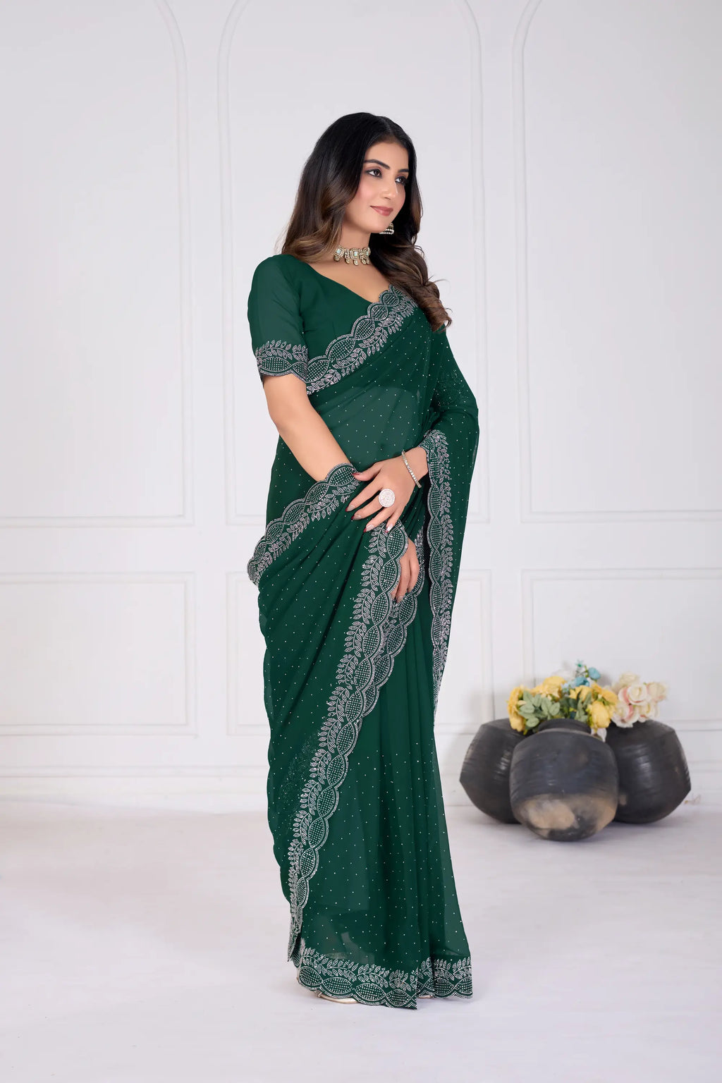 Woman wearing a green saree with lace details on a white background